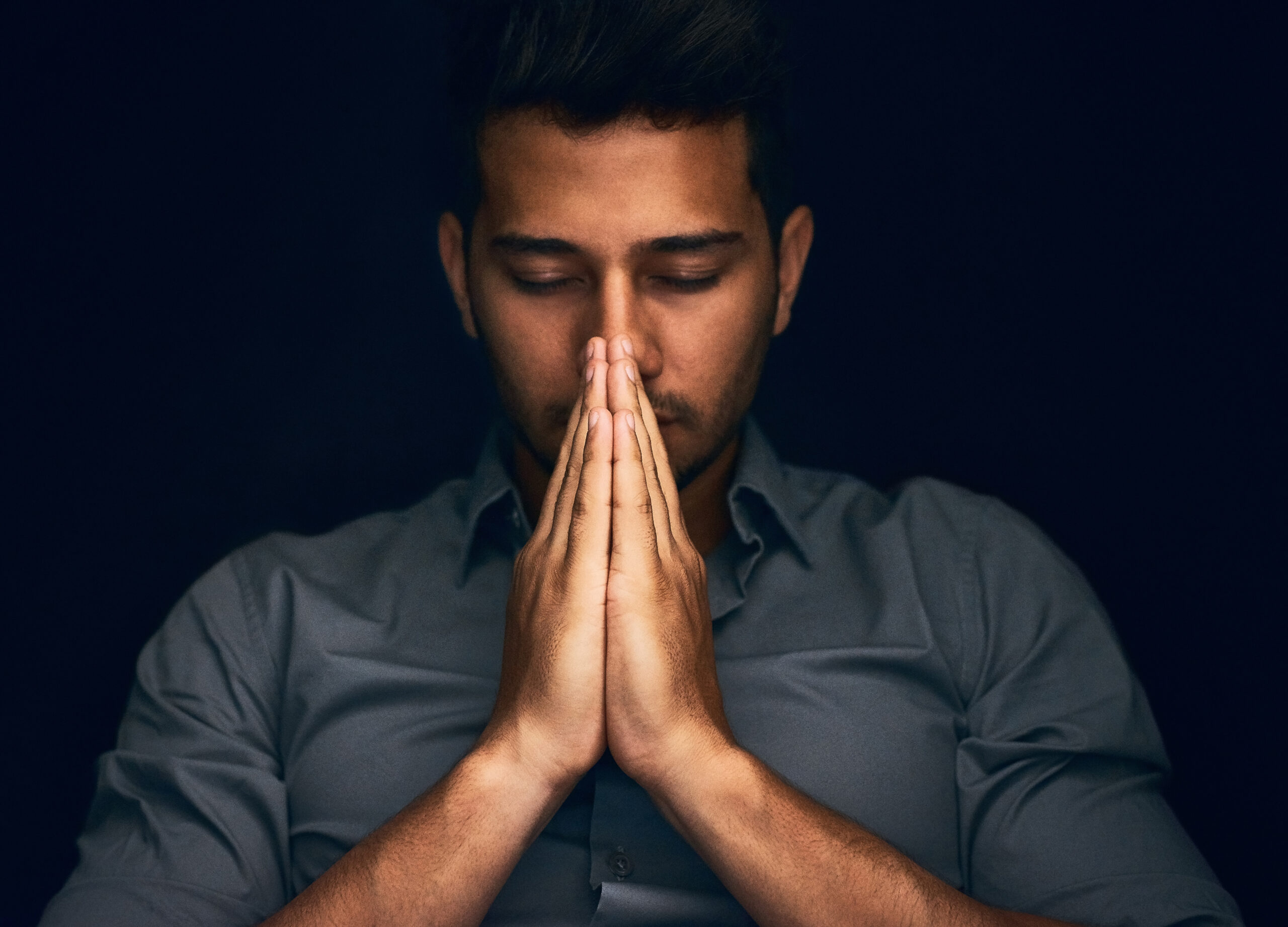 A man folds his hands in a prayer position. His eyes are closed. To heal your soul, you have to look within.