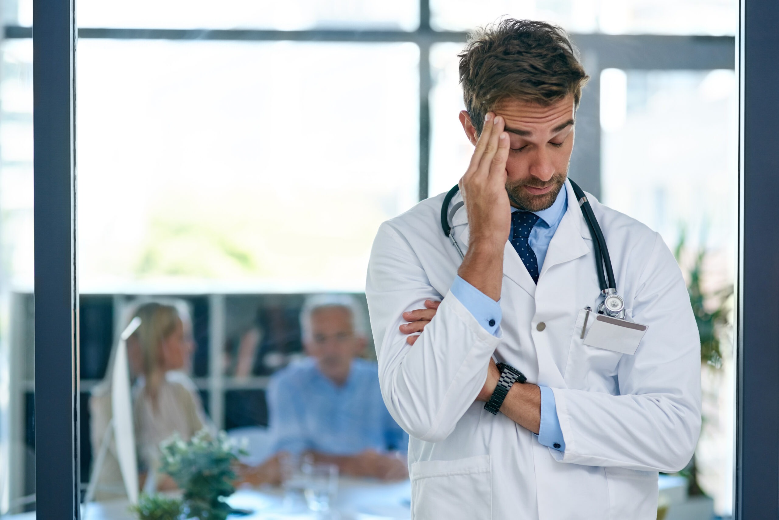 Doctor Frustrated with hand on temple. When High Performance Becomes Self-Abandonment