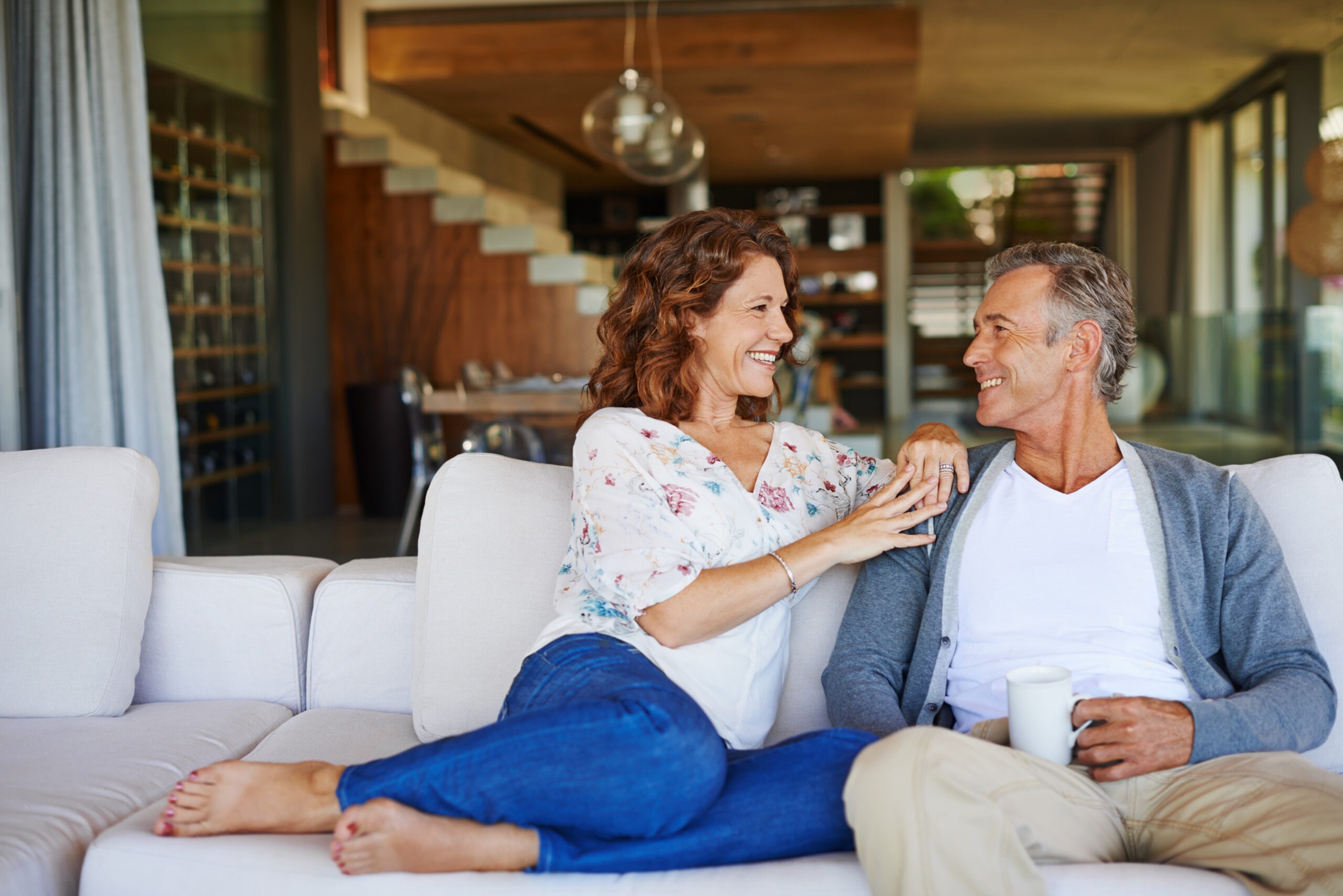 When Love and Legacy Are on the Line: Why High-Net-Worth Couples Need More Than Therapy. Couple sitting on couch cuddling.