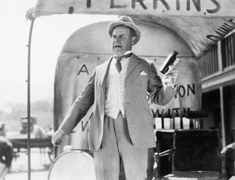 Conman is standing in front of a vintage cart selling fake cures. Blog by Dr. D Ivan Young, MCC on Building a Brand & the Credibility Crisis