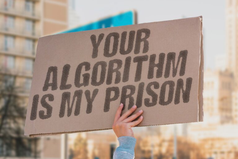 Picture of sign with Your Algorithm is my prison be held up by one visible hand.Doomscrolling – Protecting Psychological Safety article by Dr. D Ivan Young